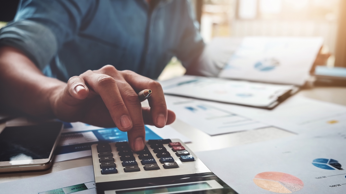 Business accounting concept, Business man using calculator with computer laptop, budget and loan paper in office.